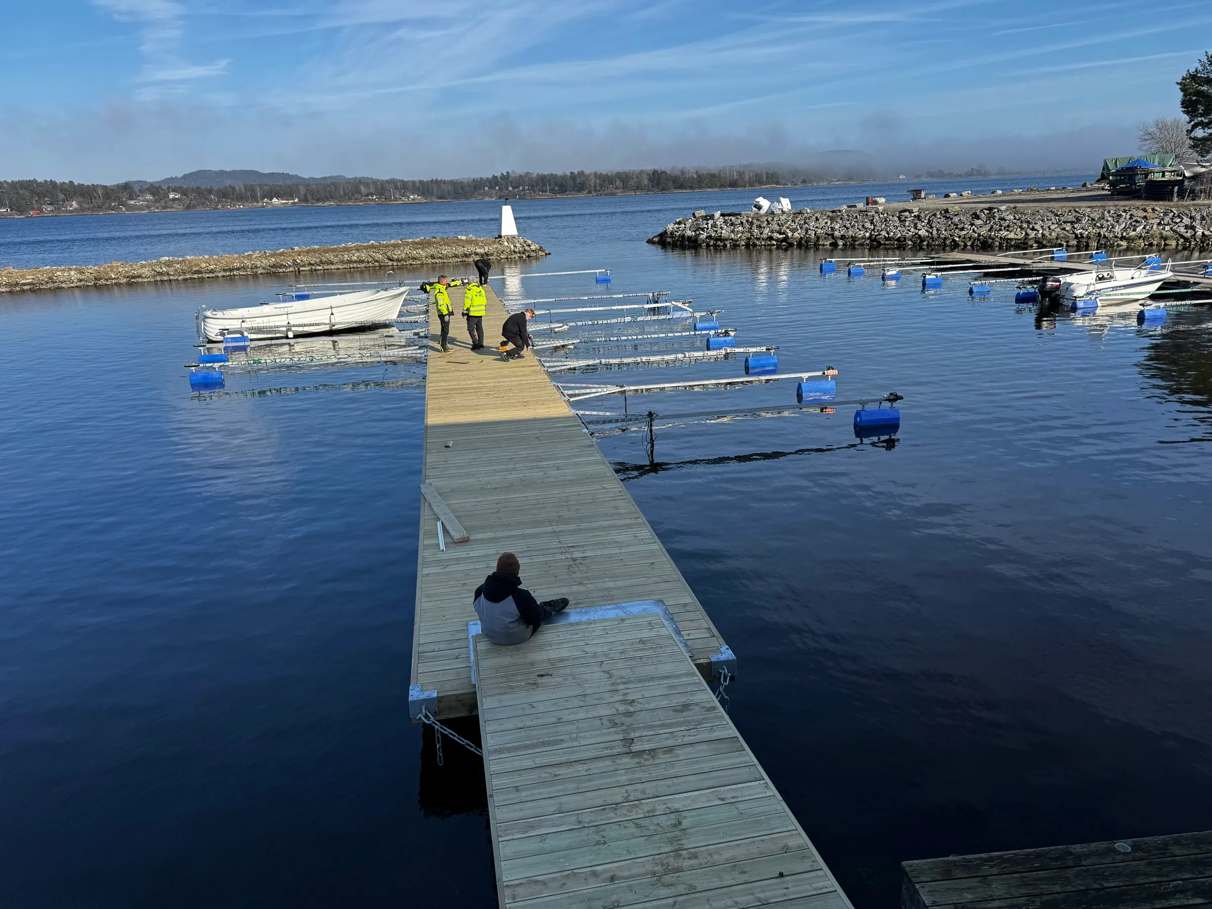 Bryggeanlegg med ferdig tredekke og utriggere under sluttmontering.